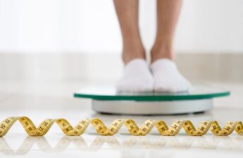 woman on scale with measuring tape